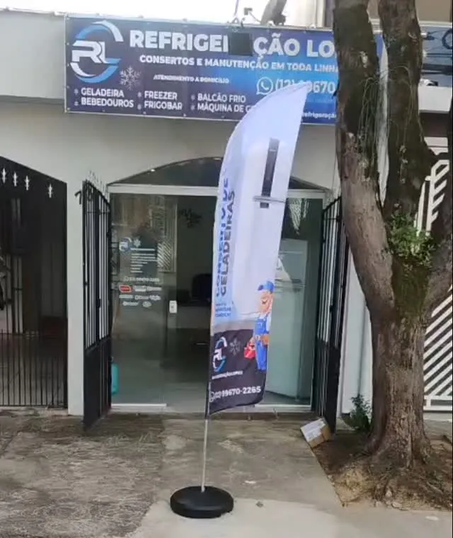 Fachada da Refrigeração Lopes com placa e banner na calçada