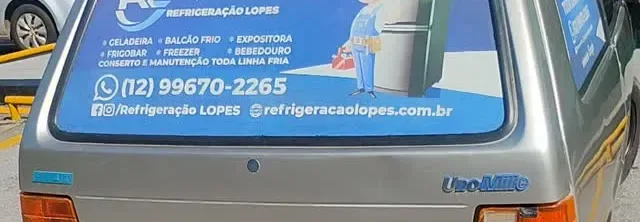 Vidro do carro da Refrigeração Lopes adesivado com os serviços e o WhatsApp