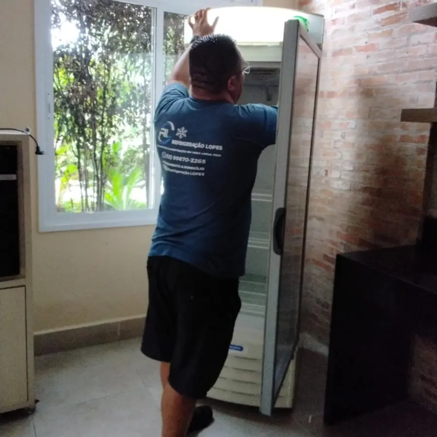 Técnico da Refrigeração Lopes ajustando um expositor numa residência