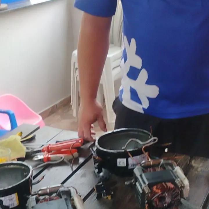 Motor de geladeira aberto na bancada para reparo